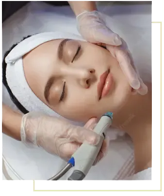 A woman lying back with her eyes closed and a white headband on, while a gloved aesthetician runs a hydradermabrasion handpiece along her jaw.