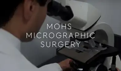A clinician examining tissue through a microscope in the lab, captioned "Mohs Micrographic Surgery."