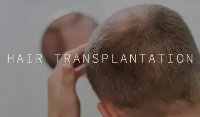 A clinician’s hand at the back of a man’s thinning scalp, captioned "Hair Transplantation."